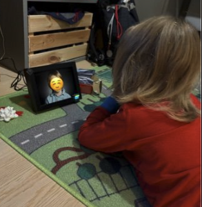 Et barn som ligger på gulvet og stirrer på foto-rammen